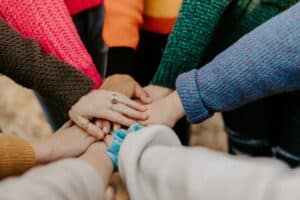 girl friends in support group for teens hands piled together